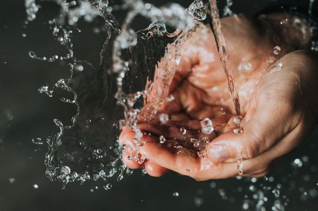 Clean water being poured in hands to emphasise the importance of drinking water standards.