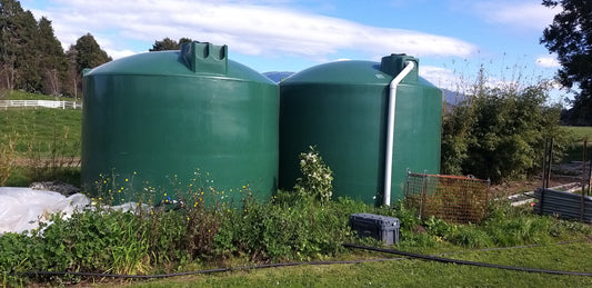 Two green plastic water tanks
